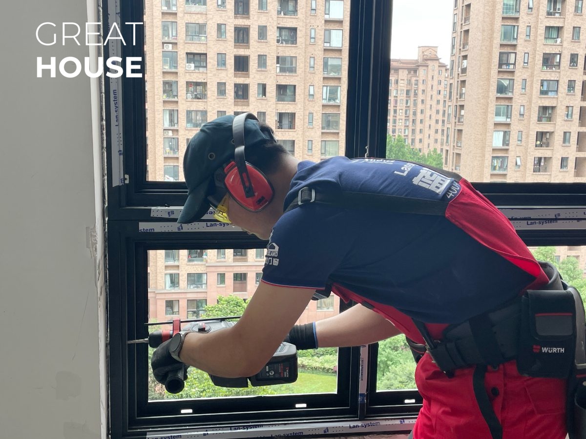 Installer fastening an aluminum window frame on site